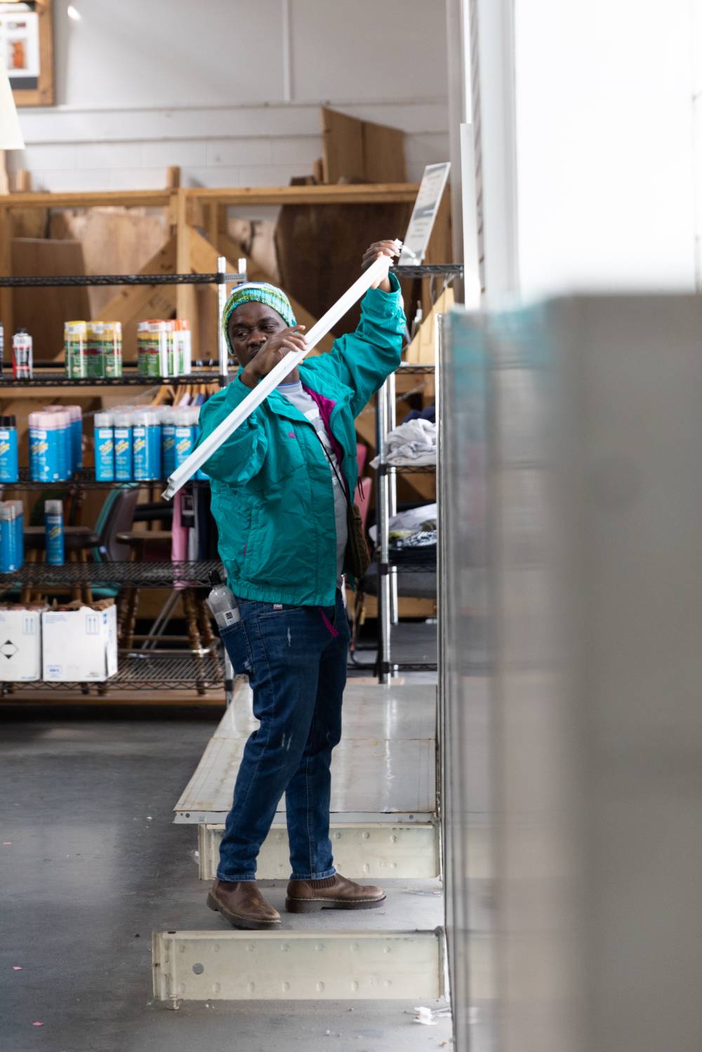 A participant helps put things on a shelf at Restore.